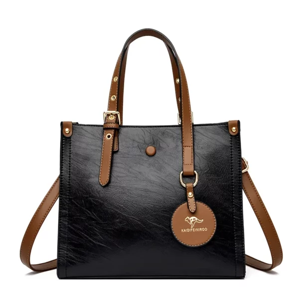 Handväska i svart läderlook med elegant vintage-design. Perfekt för dam som söker en stilfull och rymlig vardagsaccessoar.