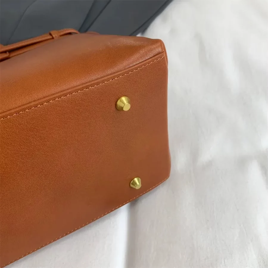 Brun handväska för dam, rymlig nog för mobil, smink och tillbehör. En praktisk och elegant accessoar som kombinerar funktion och stil.